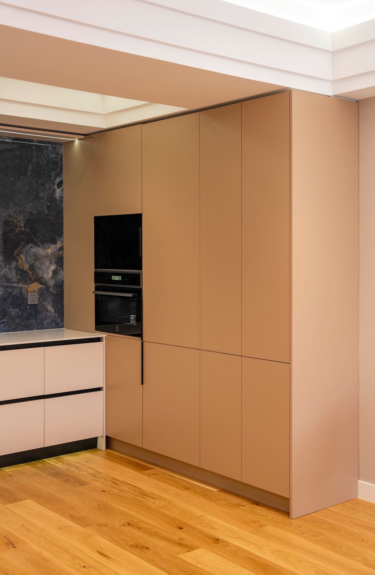 Modular kitchen with full-height cabinetry, integrated appliances and wooden flooring