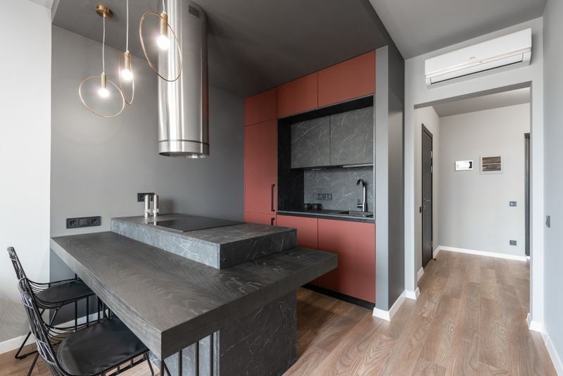 Island kitchen layout with a marble-topped island and pendant lamps