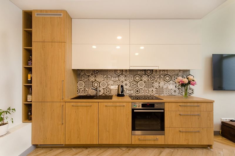 L-shaped modular kitchen with wooden cabinets and a geometric tile backsplash
