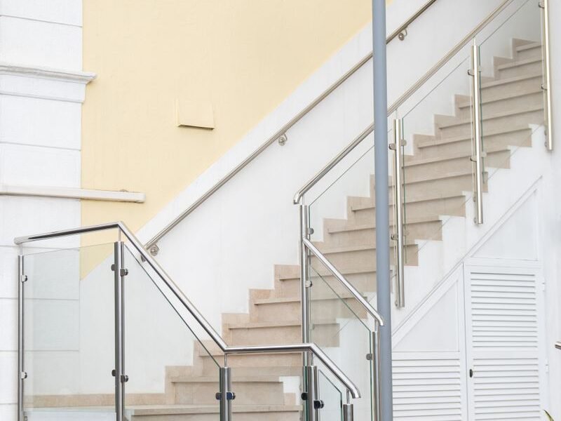 Toughened glass railing with a metal handrail on an indoor staircase