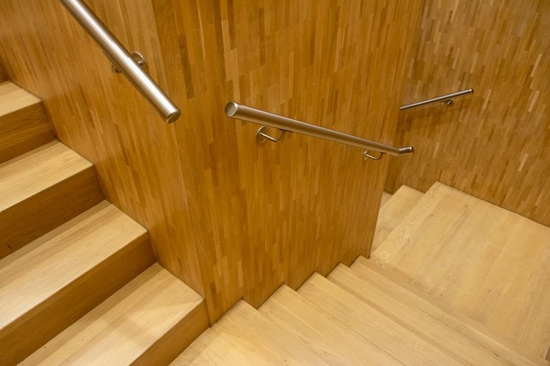 Wooden staircase fitted with a slim stainless steel handrail