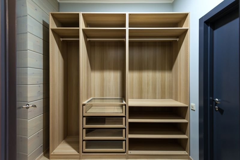Hinged-door wooden wardrobe with internal shelves and drawers